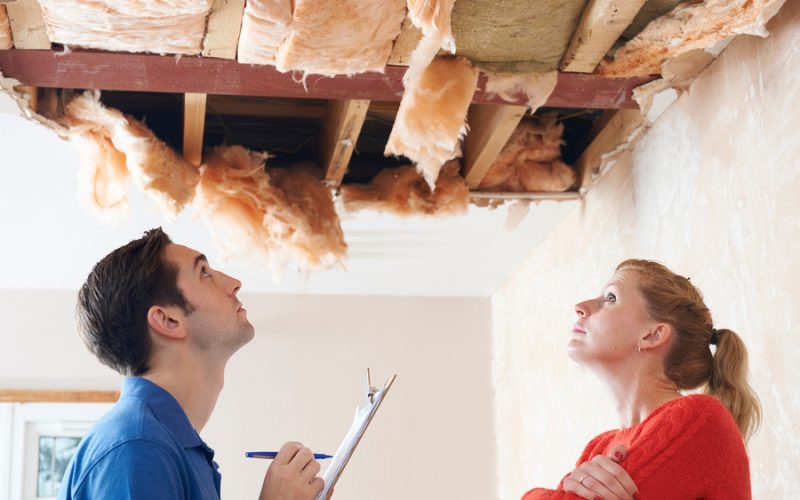Builder And Client Inspecting Roof Damage Together