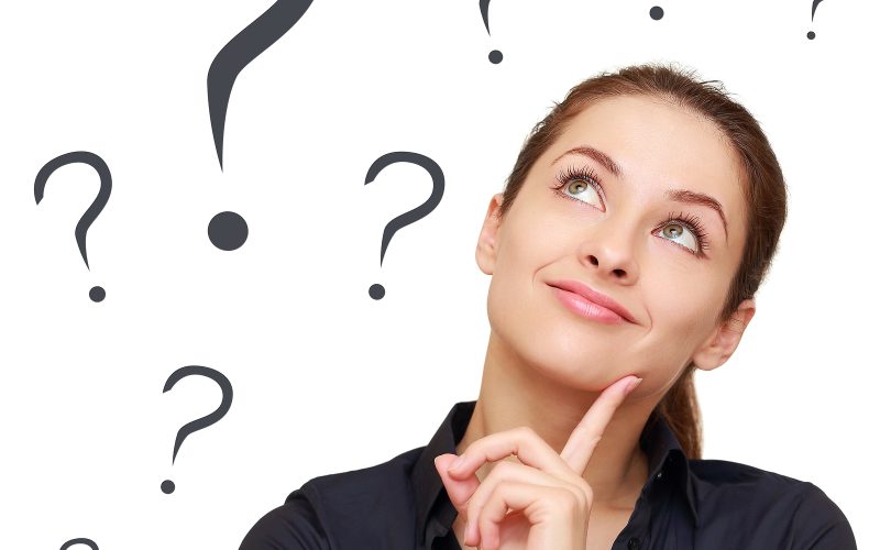 Thinking business woman looking up on many questions mark isolated on white background