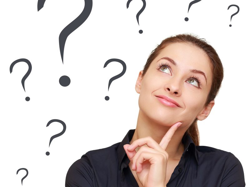 Thinking business woman looking up on many questions mark isolated on white background